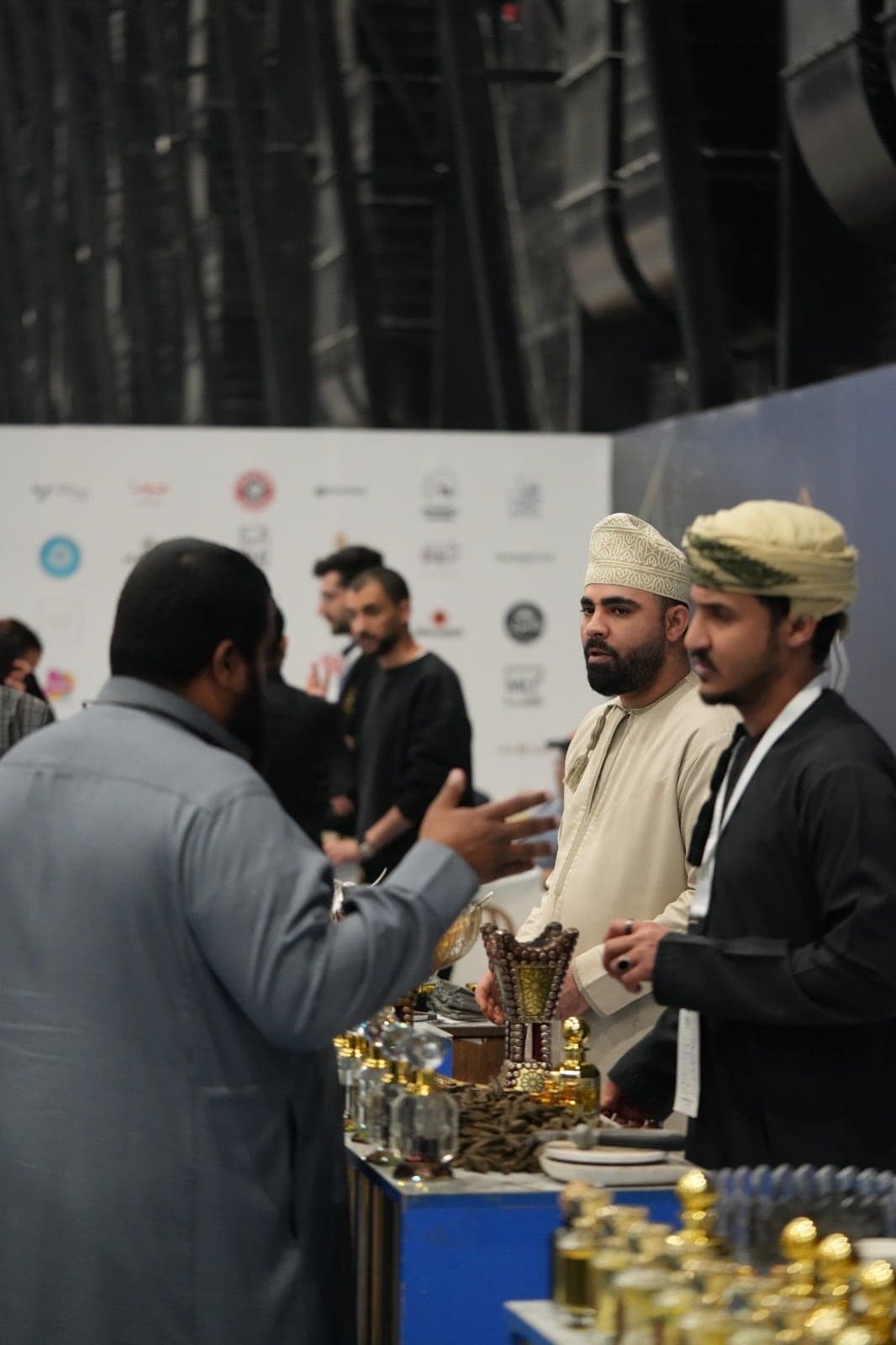 وفود من دول الخليج يتبادلون الأحاديث أمام جدار شعارات العلامات